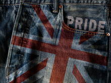 UK Flag On Jeans Denim Texture With Pride Word. Closeup Of United Kingdom Flag Or Union Jack Flag On Denim Jeans With Pride Text.