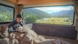 © zephyr_p - Young Asian man working with laptop computer on the bed in camper van with mountain scenic view through the window, digital nomad on road trip concept