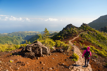 young woman hiking on path to pico ruivo, highest peak of madeira island, portugal