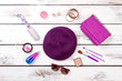 Purple women's accessories. Violet beret hat, purse, comb and brushes. Flat lay, top view.