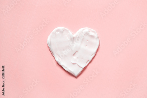 Fotomural Heart shape from cream in pink background. Skin care.