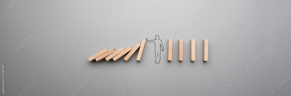 Wide cropped image of the outline of a businessman stopping the domino - obrazy, fototapety, plakaty 