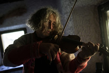 Elderly Male Musician Playing A Violin At Home