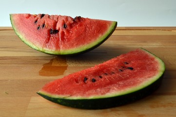 two slice of juicy watermelon con wooden surface