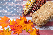 Two Bales Of Hay On  USA Flag With Leaves And Corn For Harvest Theme