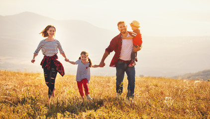 Happy family: mother, father, children son and daughter on sunset