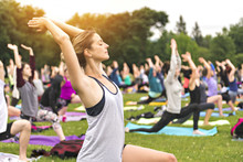 Big Group Of Adults Attending A Yoga Class Outside In Park