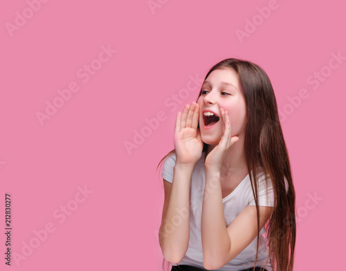 Fotomural Brunette girl screaming loud to the side against pink background