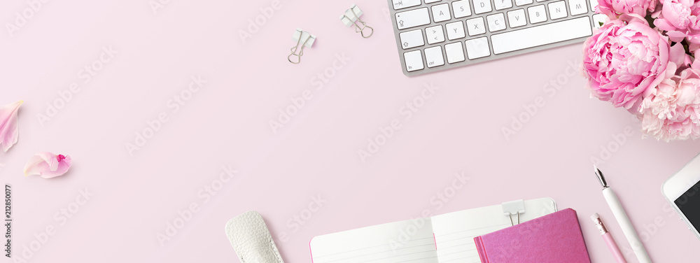 feminine banner or shop header with office / writing supplies, technical gadgets, smartphone and a bunch of pink flowers on a pink background - copyspace for your text and  branding - top view - obrazy, fototapety, plakaty 