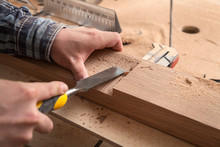 Close Up Of Young  Man Builder Wearing In A Plaid Shirt   Treating A Wooden Product With A Chisel In The Workshop, Close-up