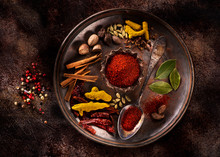 Indian Spices And Herbs On A Plate On A Dark Concrete Background