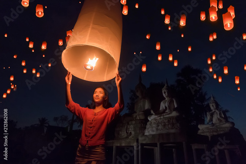 Fotografie, Obraz Women release Khom Loi, the sky lanterns during Yi Peng or Loi Krathong festival in Chiang Mai, Thailand