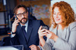 © Svyatoslav Lypynskyy - Businessman and businesswoman at working space communicating on phone. Modern office, coworkers sitting at table. Toned concept.