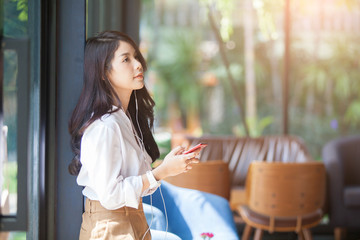 Portrait of beautiful asian woman listening to her music from Smartphone