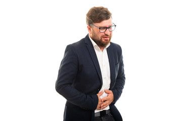 Wall Mural - Portrait of business man showing stomachache pain gesture.