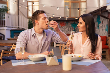 Eating seafood. Handsome blonde-haired man feeling relaxed while enjoying eating seafood with girlfriend