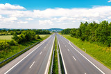 Fototapeta Do pokoju - Leere Autobahn durch grüner Landschaft