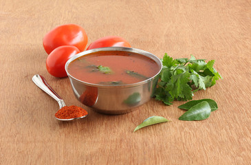 Wall Mural - Tomato rasam, a traditional, popular and healthy south Indian vegetarian semi-liquid food is consumed as an appetizer or eaten with mixing the rasam with rice, and its main ingredients.