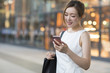 © Blue Jean Images - Smiling businesswoman using smartphone outdoors