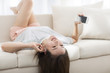 © Blue Jean Images - Woman listening to music while lying on sofa at home