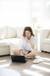 © Blue Jean Images - Cheerful young Chinese woman using laptop at home