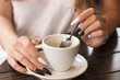 © Robert Petrovic - Woman's hand with long beautiful nails holding cup of coffee and stirring with tea spoon,