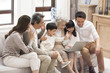 © Blue Jean Images - Happy Chinese family using laptop for video chatting