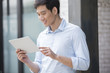 © Blue Jean Images - Young Chinese businessman holding a digital tablet outdoors