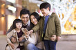 © Blue Jean Images - Cheerful young Chinese family using smart phone