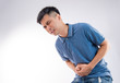 © RomixImage - Man putting his hands for belly or stomach ache on white background