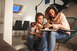 © BalanceFormCreative - Two best female friends looking at family album.They sitting in living room and drinks coffee.