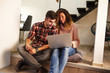 © BalanceFormCreative - Young couple sitting in living room and using laptop.Shopping online.