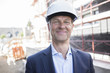 © Westend61 - Portrait of confident architect wearing hard hat on construction site