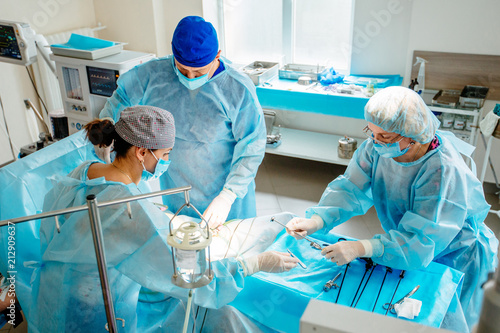 Fotografía View from above surgeons team preforming operation in hospital operating theater, male surgeon operating patient in operating room,,working with surgical laparoscopy instruments
