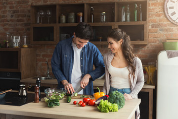 Wall Mural - Happy couple cooking healthy food together