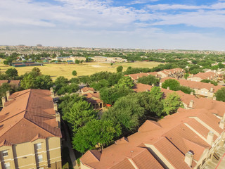 Wall Mural - Aerial view multi-floor apartment buildings complex near recreational park in Irving, Texas, US. Top view garage with covered parking lots, cars and green trees