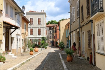 Collobrières, French. A woman walks in a typical street of the city center of the French old town.