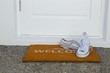 © Wavebreak Media - Canvas shoes on a door mat