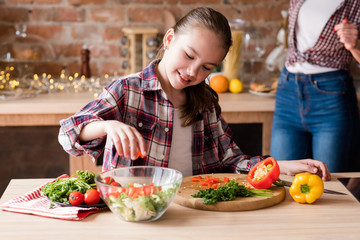 happy family cooking time. mom and daughter preparing meal in the home kitchen