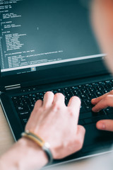 programmer writing code on his laptop. web developer designing application. internet technologies concept