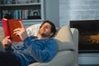 © Wavebreak Media - Man reading a book while lying on sofa in living room