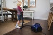 © Wavebreak Media - Boy using vacuum cleaner in living room