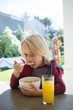 © Wavebreak Media - Boy having breakfast in porch