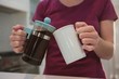 © Wavebreak Media - Woman pouring black coffee into mug in kitchen at home