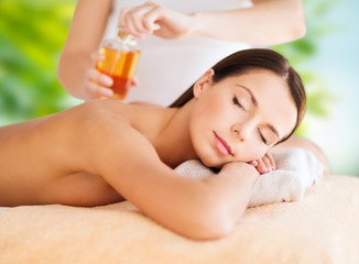 wellness, spa and beauty concept - close up of beautiful woman having massage over green natural bac