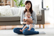 © Syda Productions - family and motherhood concept - happy smiling young asian mother with little baby at home
