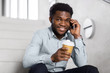 © Syda Productions - business, technology, communication and people concept - african american businessman calling on smartphone and drinking coffee at office stairs