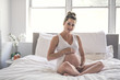 © Louis-Photo - Happy pregnancy sitting on bed at home