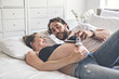 © Louis-Photo - Man with pregnant woman in bed at home having great time
