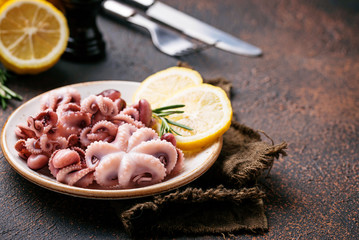 Baby octopus in plate with lemon and rosemary